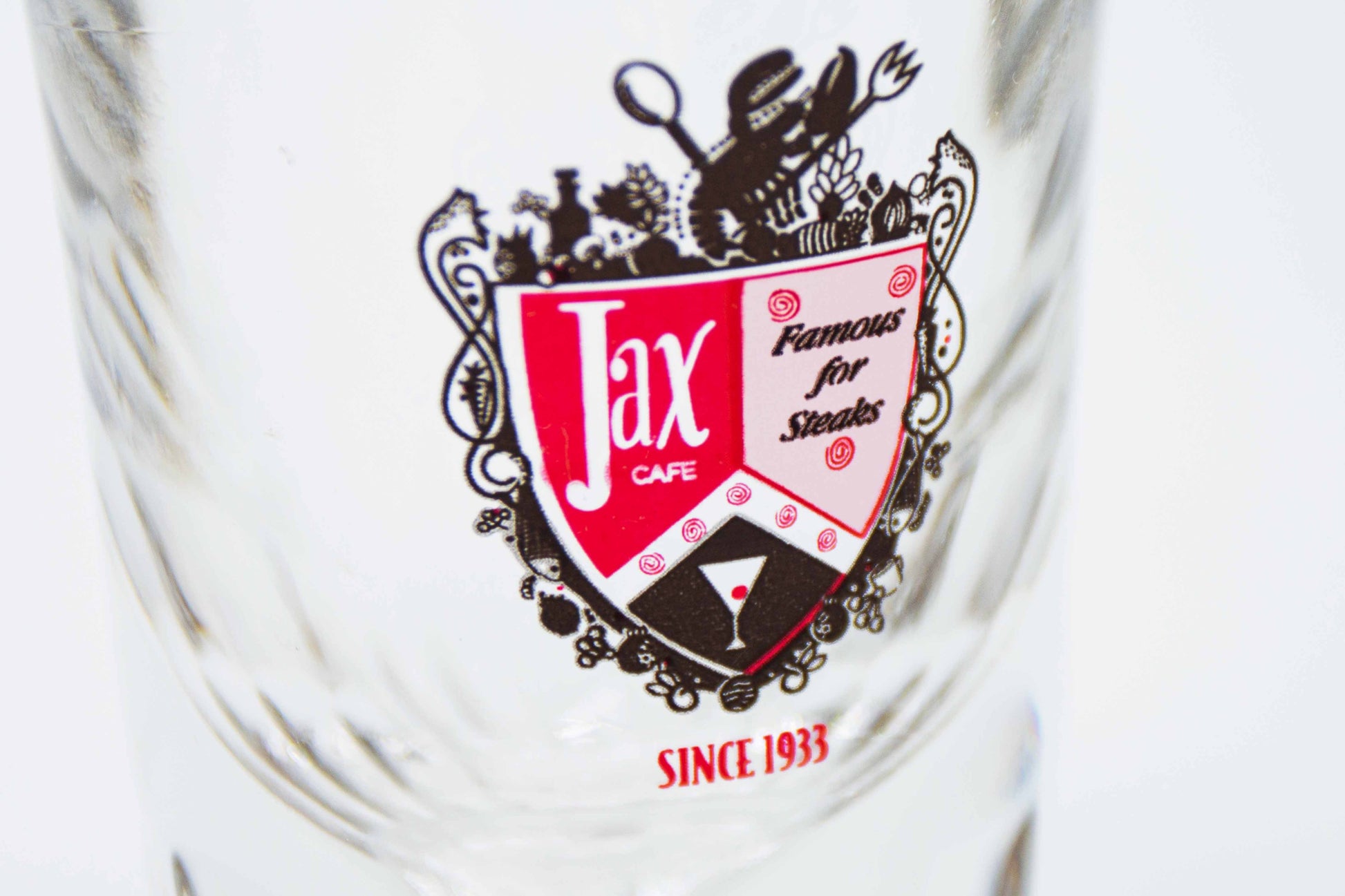 Close up of the shot glass with the text "jax cafe famous for steaks since 1933"