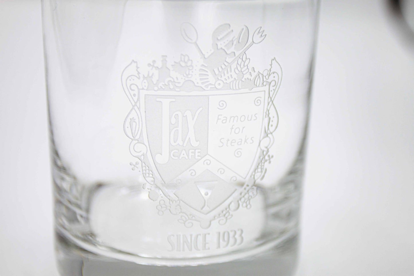 Close up of the cocktail glass with the text "Jax Cafe Famous for steaks since 1933"